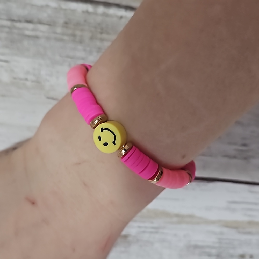 Clay bead bracelet with pink beans and a yellow smiley face